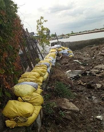 WORKERS install sandbags along a riverbank in Malabon City to help prevent flooding, as the Malabon-Navotas Navigational Gate remains under repair