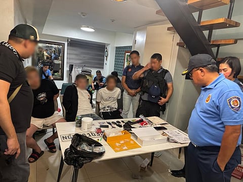 THREE Chinese nationals arrested in a Makati raid sit in front of recovered items during the rescue of a kidnapped Vietnamese woman.