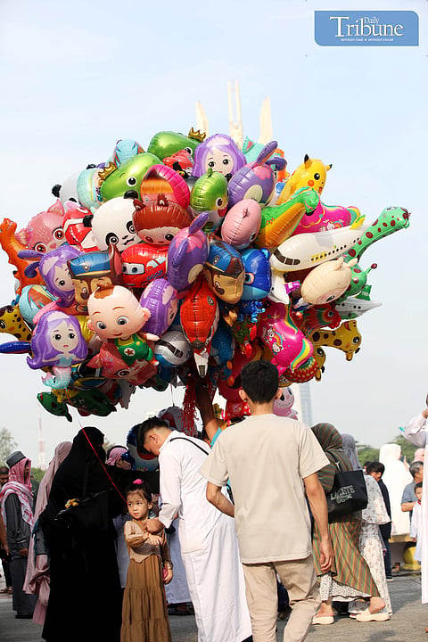 FILIPINO Muslim parents buy colorful balloons for their children during the Eid al-Adha celebration at Quezon City Circle on Friday, 6 June 2025.