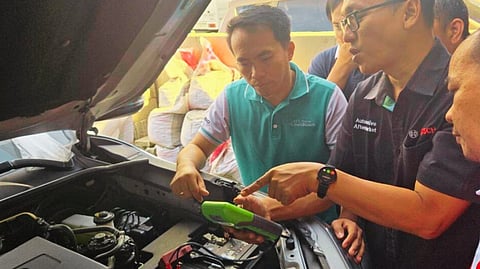 BOSCH representatives demonstrate proper battery testing procedures during a hands-on training session.