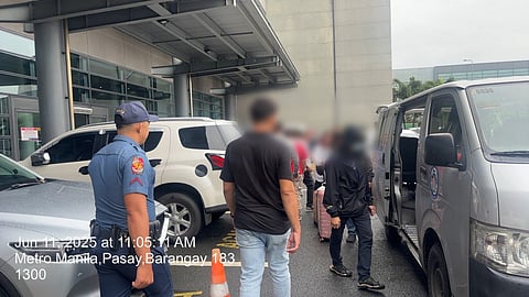 AUTHORITIES escort a male passenger arrested at NAIA Terminal 3 over a pending VAWC case.