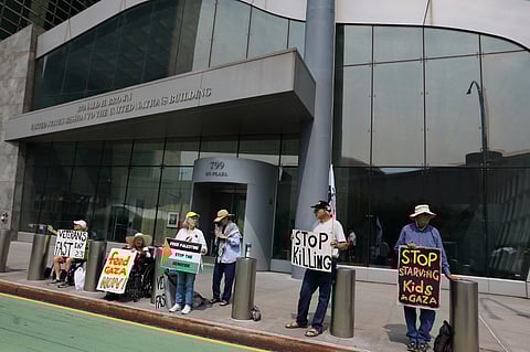 NEW YORK, NEW YORK - JUNE 13: People hold signs as they protest Israel outside the United States Mission to the United Nations building on June 13, 2025 in New York City. Ambassador Danny Danon issued a statement following Israel's strikes across Iran, which targeted nuclear facilities and killed senior nuclear scientists, top government officials, Iran’s highest-ranking military officer, and the head of the Islamic Revolutionary Guard Corps. Iran's Foreign Minister Abbas Araghchi has requested a meeting at the Security Council over the strikes. 