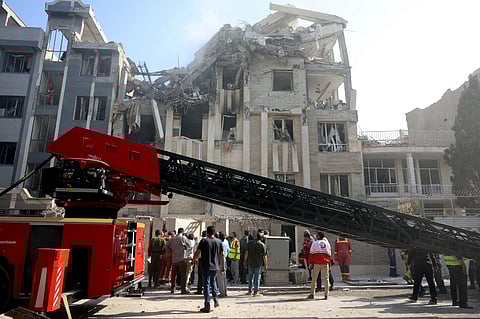 Rescue teams work outside a heavily damaged building, targeted by an Israeli strike in the Iranian capital Tehran on June 13, 2025. Israel carried out strikes against Iran early on June 13, targeting its nuclear and military sites as well as residential buildings in Tehran, after US President Donald Trump warned of a possible "massive conflict" in the region.
