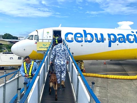 AN aviation security officer inspects Cebu Pacific Flight 5J851 following a bomb threat No explosives were found during the inspection.