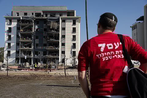 A MEMBER of the local emergency services watches the destruction at the site of an Iranian missile attack in a residential area in Beersheba in southern Israel, on 20 June. Israel and Iran exchanged fire again, a week into the war between the long-time enemies. 