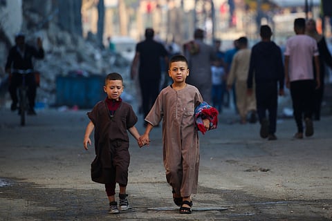 Two children leave after participating in a special morning prayer on the first day of the Muslim Eid al-Adha festival in Nuseirat, central Gaza Strip, on 6 June 2025, amid the ongoing war between Israel and the militant movement Hamas.