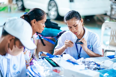 A GCash representative assists a 4Ps beneficiary in setting up her pre-loved phone. 