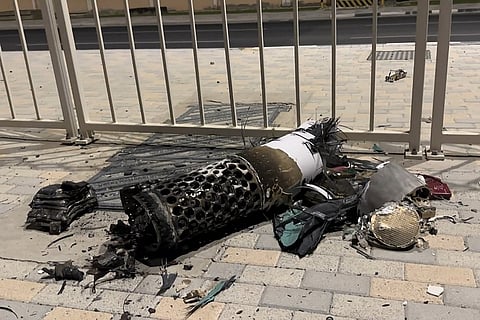 This frame grab take from AFPTV footage shows the remnants of an Iranian missile intercepted over Qatar, as it lies on a pavement near a fence on 23 June 2025. Qatar said on 23 June, the security situation was "stable" following an Iranian missile attack that targeted a US base on its territory in retaliation for American attacks on Iran nuclear sites.
