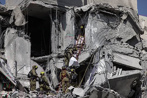 ISRAELI emergency responders and security personnel search for casualties in the rubble of a building struck by an Iranian missile in Beersheba, southern Israel, on Tuesday. 