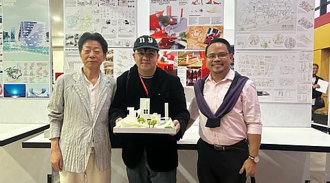 Thomasian student Kristian Tacbian (center) holds his work, accompanied by UST College of Architecture assistant professor Ar. Noel C. Cruz (right) 
