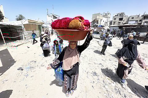 PALESTINIANS move with their belongings following Israeli evacuation orders for Khan Yunis on 19 May. Israel said it will “take control” of the whole of Gaza, where rescuers reported more than 50 killed in Israeli strikes as the military pressed a newly intensified campaign.
