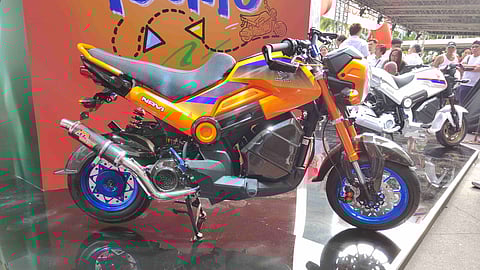 A Honda Navi grabs attention with its custom orange and blue setup at the launch event.