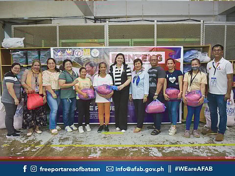 Officials from DOLE Region 3, AFAB, as well as employees from a Bataan Freeport company pose to show the rice they acquired thru the Benteng Bigas Meron Na” program of the government.