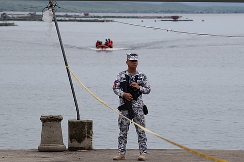 A PHILIPPINE Coast Guard serviceman keeps watch at a pier in Taal Lake near Laurel town, Batangas province where authorities search for missing cockfighters.