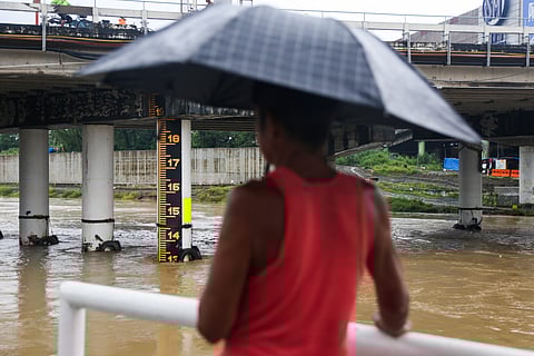 Residents monitor the water level of Marikina River  while others take advantage of the strong currents to catch freshwater fisher on the afternoon of 19 July 2025,as Severe Tropical Storm Crising and Habagat brought heavy rains to Metro Manila. PAGASA has issued a yellow warning level for Metro Manila at 2:00 pm today for possible flooding in flood-prone areas.