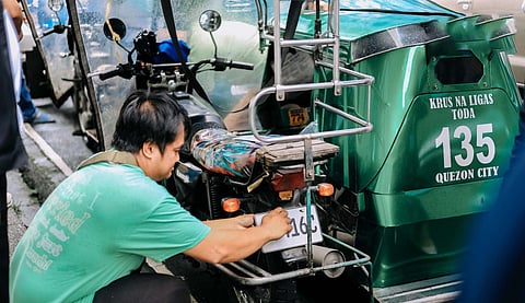 Old trike, new license plate A tricycle driver secures his newly issued license plate during a distribution event by the Land Transportation Office for TODA members in Quezon City, part of the agency’s nationwide registration campaign.  