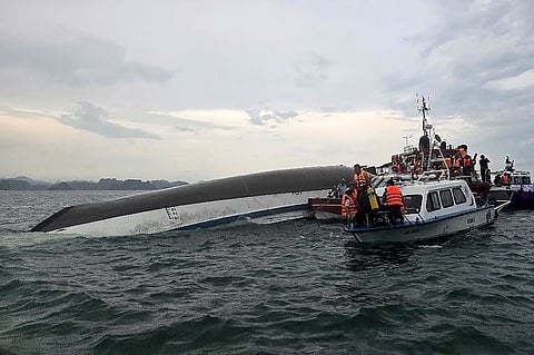 THIS handout photograph taken on July 19, 2025 and released by the Vietnam News Agency (VNA) shows relief personnel gathered around a capsized tourist boat (L) during a search and rescue operation in the Ha Long Bay, Quang Ninh province. At least 18 people have died and dozens remain missing after a tourist boat carrying more than 50 people capsized on July 19, in Vietnam's Ha Long Bay, state media said.