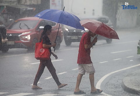 RAINY MONDAY: Pedestrians use umbrellas to shield themselves from the heavy downpour in Quezon City on Monday, July 21, 2025. While the newly formed low-pressure area (LPA) is not expected to directly affect the country, PAGASA said it has intensified the southwest monsoon or habagat, bringing more rain across the Philippines.