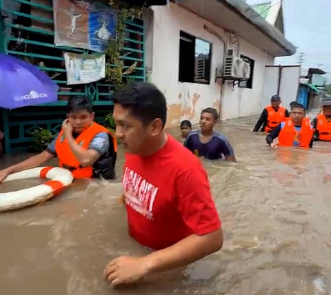 Rescuers and residents are having a hard time going through Barangay Maligaya in Floridablanca, Pampanga, due to the waist-deep flooding experienced after Tropical Storm Crising and heavy rainfall from the southwest monsoon dumped rainwater in the province. 