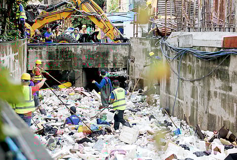 Workers from the Metropolitan Manila Development Authority clear out garbage at Maligaya Creek in Caloocan City as part of the flood mitigation programs of the government.