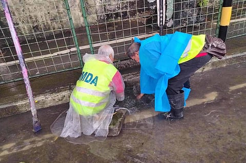 MMDA personnel declog a canal in Metro Manila on Monday, July 21, 2025 as rains brought by southwest monsoon (Habagat) have caused flooding in several areas.
