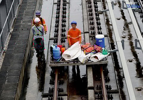 MRT-7 workers walk along the train tracks near Batasan Station on Commonwealth Avenue, Quezon City, on Wednesday, July 23, 2025. The 22-kilometer elevated railway project—connecting Metro Manila and Bulacan through 14 stations—is now 83.08% complete. Trial runs are expected to begin by the end of 2025, with full operations targeted for 2026 and a projected daily ridership of 600,000. 