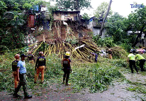 Rescuers from the Bureau of Fire Protection, Quezon City Police District, and the Quezon City local government remove toppled bamboo trunks that crushed two vehicles after a landslide along Don Vicente Street in Barangay Bagong Silangan, Quezon City, on Wednesday, July 23, 2025.