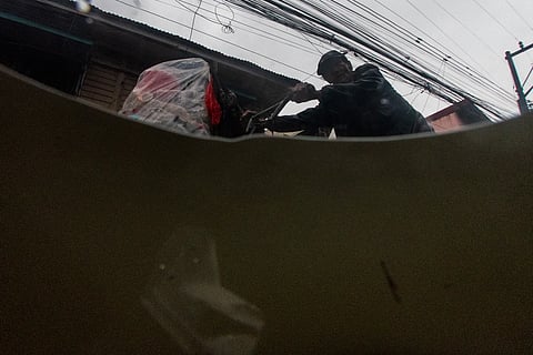 A MAN pedals his tricycle along L.R. Yangco Street in Barangay Navotas East on Thursday afternoon, 24 July 2025, amid rains brought by the southwest monsoon. He collects used PET bottles to sell at an MRF in Tondo, Manila.