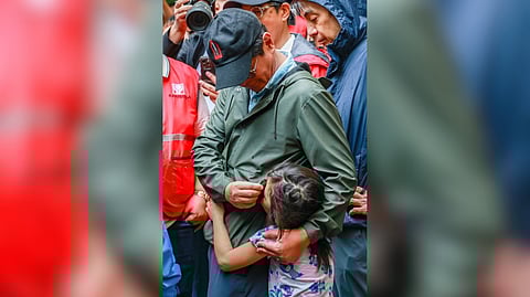 Personal touch President Ferdinand R. Marcos Jr. consoles a young girl as he meets with displaced residents at the Tanza National High School evacuation center in Navotas City on Saturday. Marcos also visited the city’s damaged flood control project amid the garbage that accumulated at the Tullahan River.
