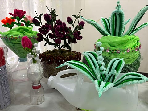 Eco-friendly products like bags, plant pots, faux lamps, and other home decors are seen after being transformed from waste materials such as elections tarps.