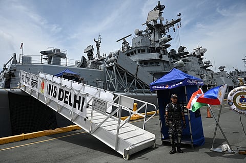 A member of the Armed Forces of the Philippines stands guard in front of the Indian Navy guided missile destroyer INS Delhi as it docked at the Port of Manila on Friday.
