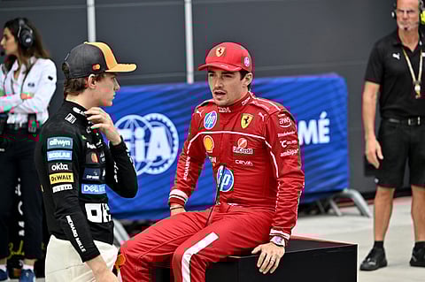 Second placed McLaren's Australian driver Oscar Piastri (L) talks with the winner Ferrari's Monegasque driver Charles Leclerc after the qualifying session of the Formula One Hungarian Grand Prix at the Hungaroring circuit in Mogyorod, near Budapest, Hungary, on August 2, 2025.
