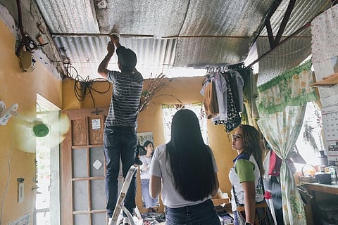 AN Alerto PH team from Wiredfield Philippines Inc. installs smoke alarms in fire-prone areas of Barangay Commonwealth, Quezon City.