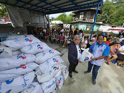 PAGCOR’s Joaquin Abejar hands over relief packages to Brgy. Igulot Chairman Eduardo Agapito for families affected by recent storms in Bocaue, Bulacan.
