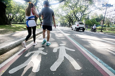 People seen walking and jogging around the academic oval of UP Diliman. The Academic Oval is open daily to walkers, joggers, and runners every day. Photo/Analy Labor