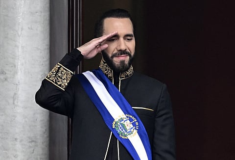 (FILES) El Salvador's President Nayib Bukele salutes during the military parade after being sworn in at the National Palace in downtown San Salvador on June 1, 2024. El Salvador's ruling-party-dominated Congress is discussing indefinite presidential reelection on July 31, 2025, aiming towards President Nayib Bukele's continued presidency. This reform also proposes extending the term of office from five to six years.
