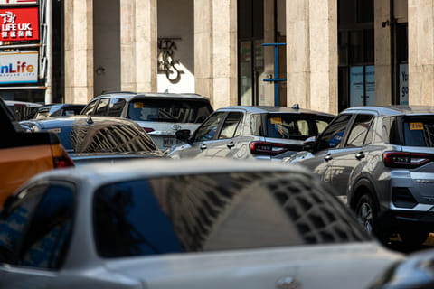 Vehicles parked along Escolta Street in Binondo, Manila, narrow the road and leave limited space for motorists and pedestrians to pass on Sunday, 3 August 2025. The Lawyers for Commuter Safety and Protection is urging the Department of the Interior and Local Government to impose a total street parking ban in Metro Manila, opposing the agency’s proposal for a partial ban.