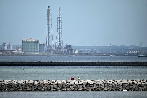 TWO people (C) sit out on a breakwater after much of coastal Japan went on tsunami alert following a 8.7 magnitude quake in the sea off eastern Russia, along Tokyo Bay in Chiba City, Chiba prefecture on July 30, 2025. A powerful 8.7 magnitude earthquake off Russia's far east has prompted tsunami alerts across parts of the Pacific including Japan, Hawaii, Russia and Ecuador, and warnings along the California coast, US authorities said.