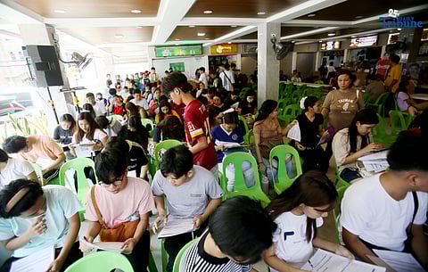 Residents line up at a satellite voters' registration center in Barangay Commonwealth, Quezon City on Tuesday in preparation for the upcoming Barangay and Sangguniang Kabataan Elections (BSKE).