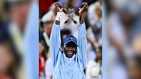Victoria Mboko proudly raises the WTA Canadian Open trophy after topping Naomi Osaka, 2-6, 6-4, 6-1, in Montreal.