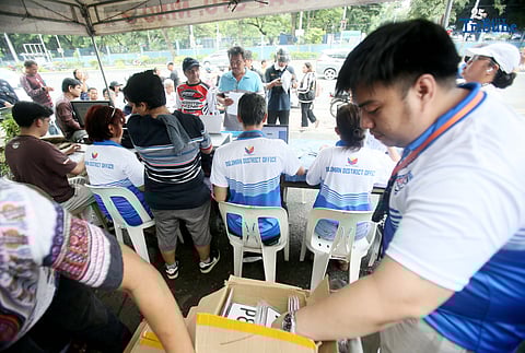 The Land Transportation Office Law Enforcement Unit assists motorcycle owners queuing for the LTO Palit Plaka program at the LTO main office along East Avenue in Quezon City on Saturday. The nationwide plate distribution program aims to address the backlog and ensure motorists comply with registration requirements.