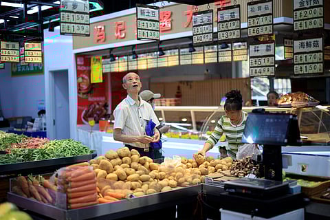A man checks prices at a market in Shenyang, in China’s northeast Liaoning province on June 9, 2025. Chinese consumer prices fell for the fourth straight month in May, data showed on June 9, as the world's second biggest economy struggles with sluggish spending and global trade turmoil.