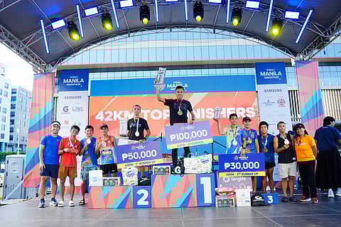 EDUARD Flores (middle) celebrates after winning the men’s full marathon event of the Galaxy Manila Marathon on Sunday at SM Mall of Asia Grounds.