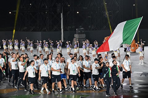 Members of Italy's delegation wave their country's national flag as they take part in the athletes' parade during the opening ceremony of the 2025 World Games at the Tianfu International Convention Centre in Chengdu, in China's southwestern Sichuan province on August 7, 2025. Italian orienteering athlete Mattia Debertolis died on August 12, 2025, at the World Games in Chengdu, after collapsing during competition, organisers said.