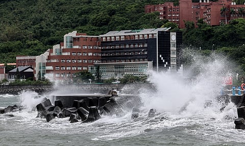 Waves generated by Typhoon Podul break along the coast in Kaohsiung on August 13, 2025. Thousands of people sheltered and fishermen secured their boats across storm-battered southern Taiwan on August 13 as Typhoon Podul intensified on its approach to the island.