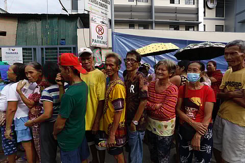 Hope on hold AKAP, short for Ayuda para sa Kapos ang Kita Program, faces zero allocation in the proposed 2026 budget, leaving countless local governments and community projects high and dry. In this file photo from last December, residents of Baseco, Manila, start lining up before sunrise at Benigno Aquino Elementary School, braving the morning chill and long queues for confiscated frozen mackerel distributed by authorities — a small taste of aid that AKAP would have helped sustain.