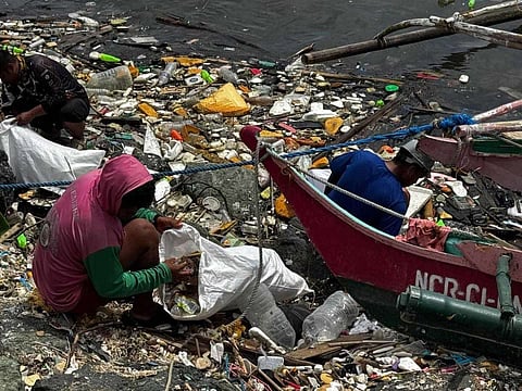 WORKERS collect trash in Pasay as part of a cleanup drive that net over 23 tons of garbage from Manila Bay.