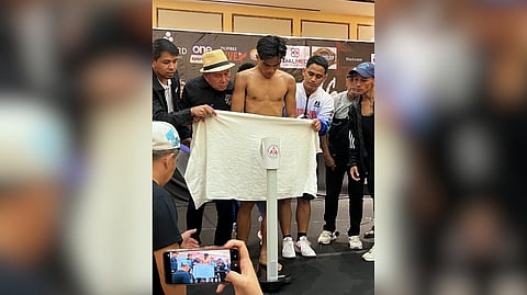 The handlers of Kenneth Llover cover the fighter with a towel after coming in 400 grams over the 118-pound agreed weight during official weighin Saturday at Winford Resort Casino.