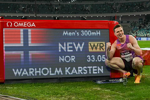 Norway's Karsten Warholm poses with his time of 33.05 seconds after he broke the men's 300m hurdles world record during the Xiamen IAAF Diamond League athletics meeting at Egret Stadium in Xiamen, in China’s eastern Fujian province, on April 26, 2025.
