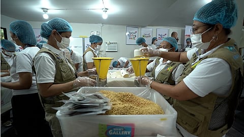 Volunteers from Prime Infra Foundation, Ahunan Power, and Rise Against Hunger Philippines pack rice-soy meals for distribution to Grades 1 to 6 students of Saray Elementary School in Pakil, Laguna.